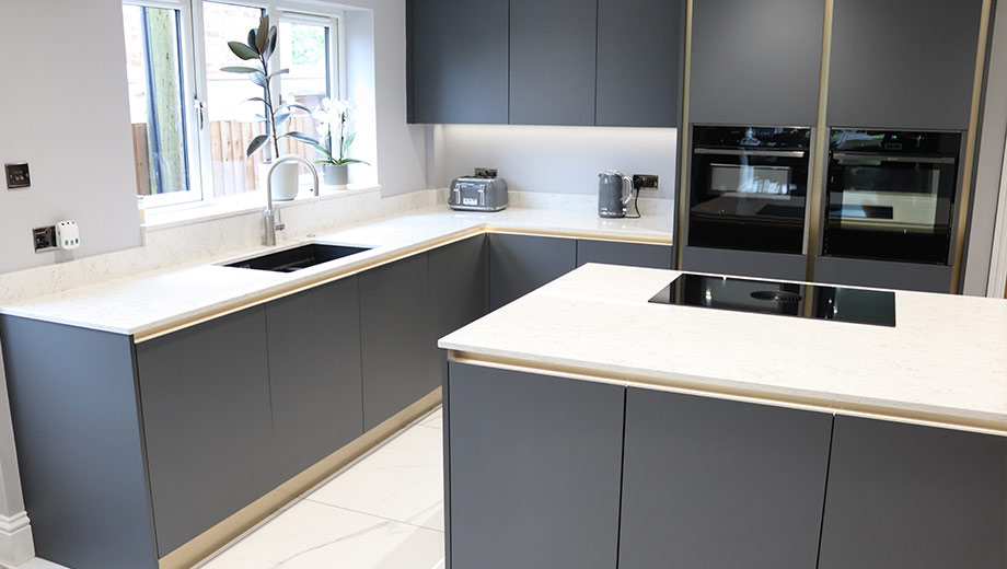 Dark handleless kitchen with gold handlerails