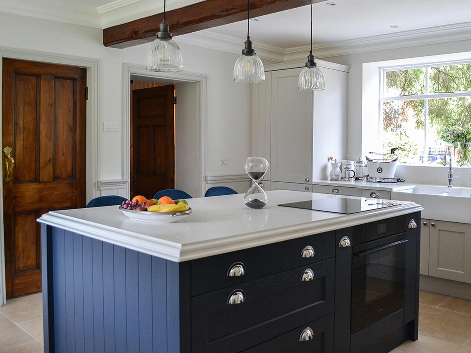 A navy kitchen island with white marble worktops